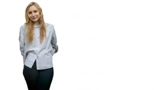 Een jonge vrouw kijkt je aan en voelt voorzichtig aan haar billen